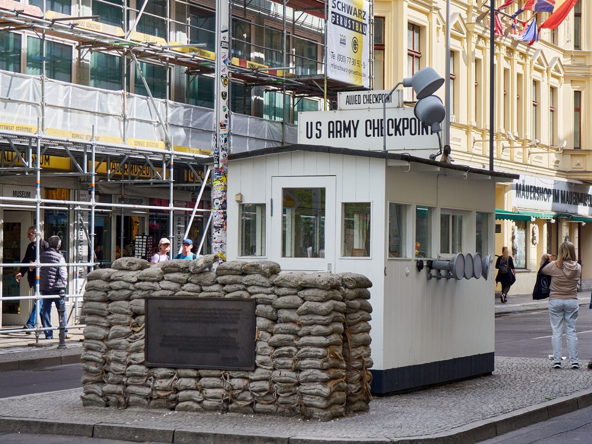 The preserved US Army guard house at Checkpoint Charlie in Berlin, used here as a visual metaphor for the two insurance coverage checkpoints.